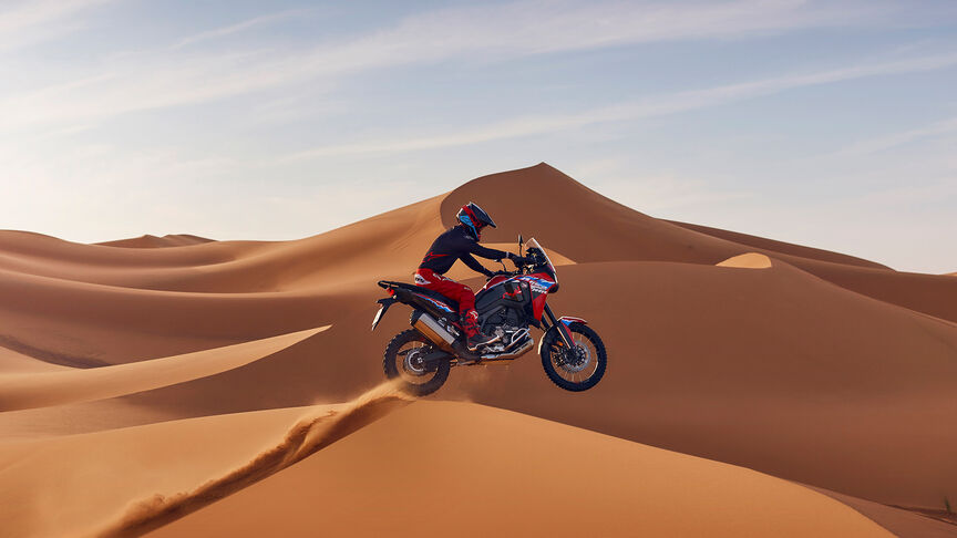 Africa Twin Off-road avec motard sur une dune de sable