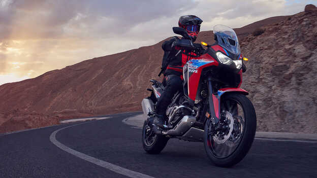 Mannequin conduisant une moto CRF1100L Africa Twin dans un environnement désertique.