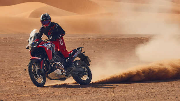Mannequin conduisant une moto CRF1100L Africa Twin dans un environnement désertique.