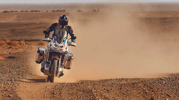 Motard vu de face sur une Honda CRF1100 Africa Twin Adventure Sports dans le désert.