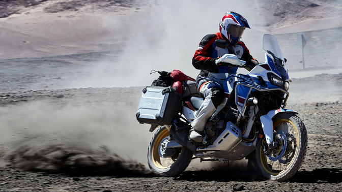 Pilote effectuant un d&eacute;rapage en tout-terrain sur une moto Honda Africa Twin Aventure Sports.