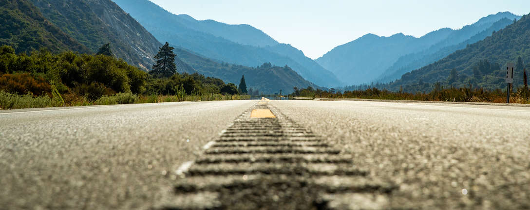 Route asphaltée déserte menant vers des montagnes