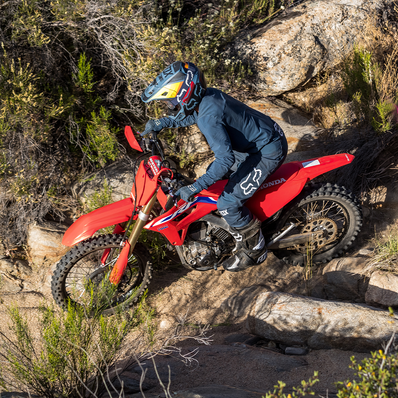 Une Honda CRF450RX en mouvement sur des rochers.