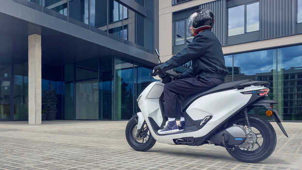 Pilote au guidon d'un Honda CUV e montrant l'assistance à la marche arrière.