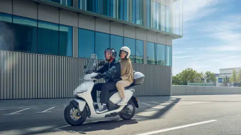 Pilotes au guidon du Honda CUV e dans un environnement urbain.