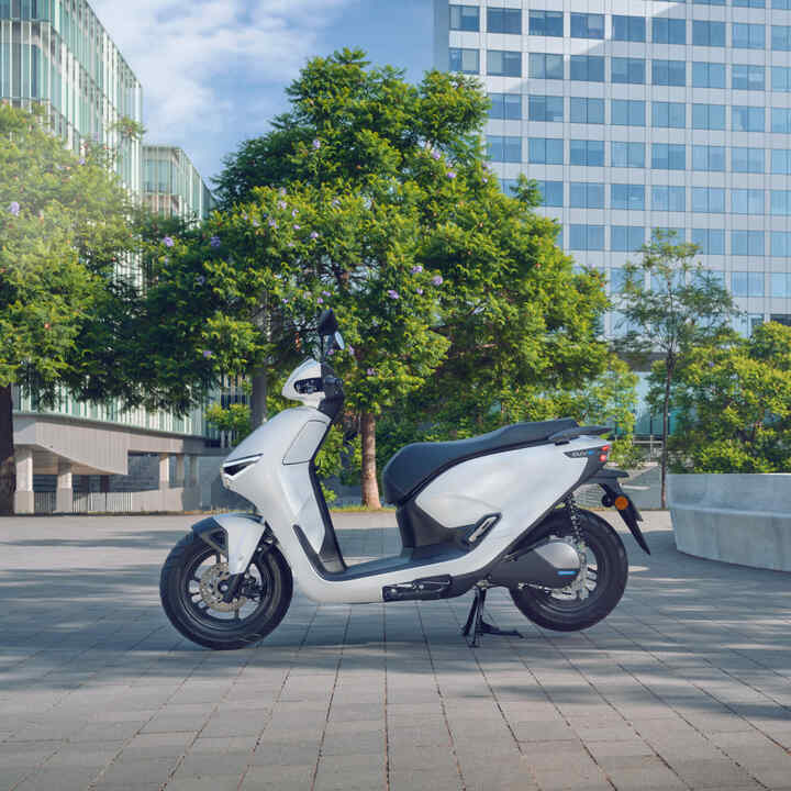 Scooter Honda CUV e garé dans un environnement urbain.