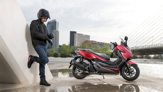 Honda Forza, garé dans un environnement urbain.