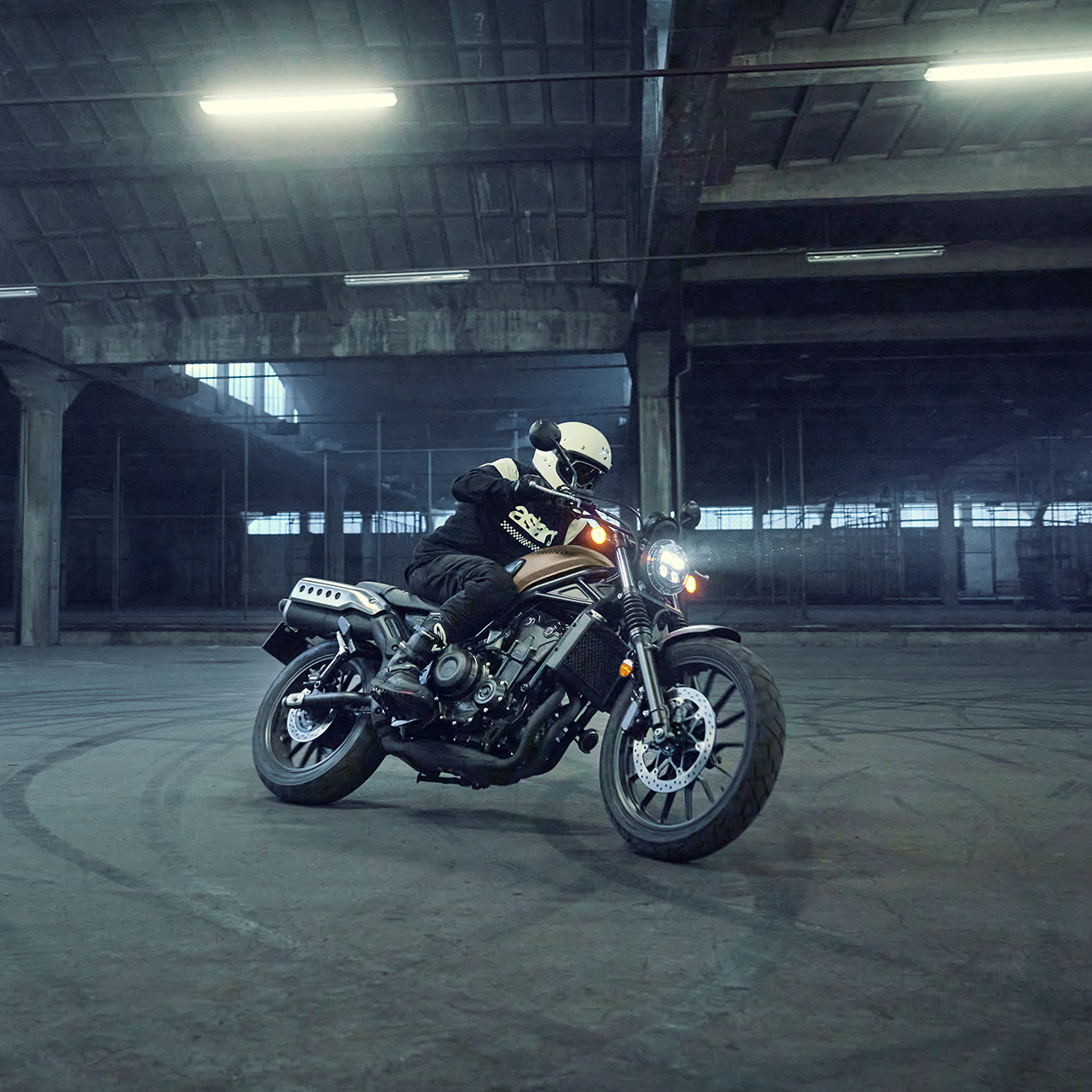 Mannequin au guidon de la moto Honda CL500 dans un parking.
