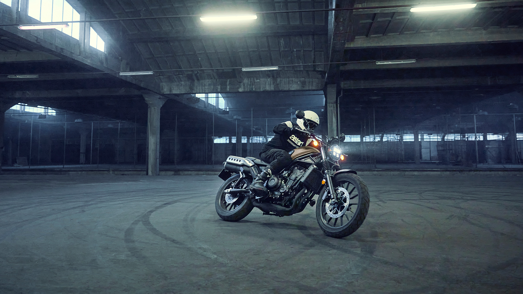 Mannequin au guidon de la moto Honda CL500 dans un parking.